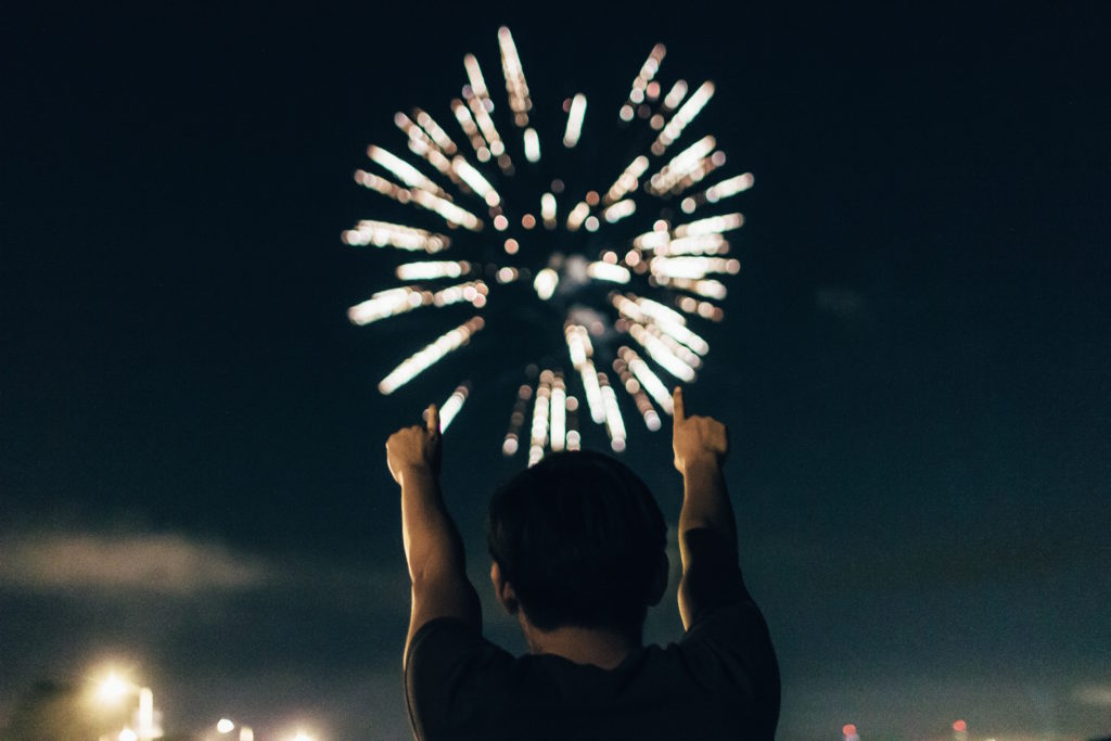 Firework exploding in the sky with a child in front